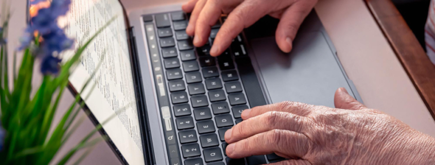 falso rimborso, le mani di una donna anziana che digita sulla tastiera