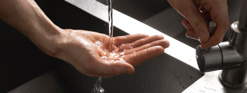 legionella, una personaraccoglie acqua da un lavabo