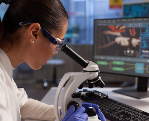 una ricercatrice a lavoro per identificare al microscopio virus e batteri