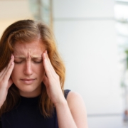 donna esausta per il mal di testa si tiene le mani alle tempie