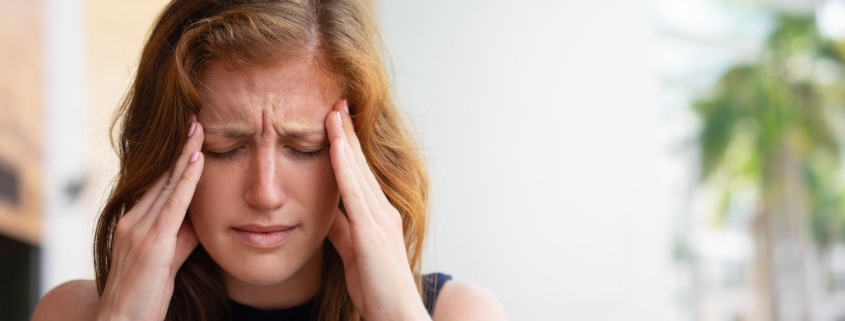 donna esausta per il mal di testa si tiene le mani alle tempie