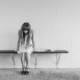 worried girl, woman, waiting, sitting, thinking, worry, sad girl, black and white, sad, expression, people, person, depression, sadness, emotion, unhappy, adult, depressed, grief, frustration, despair, human, problem, stressed, young, female, girl, long hair, dress, bench, concrete, wall