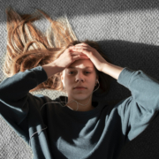 salute mentale, una giovane donna con le mani alla testa e uno sguardo preoccupato