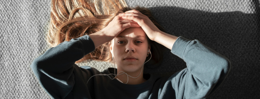 salute mentale, una giovane donna con le mani alla testa e uno sguardo preoccupato