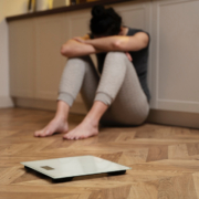 disturbi alimentari, una giovane donna seduta a terra è disperata