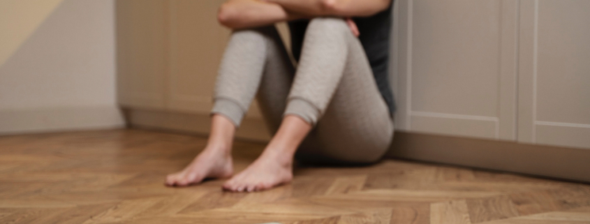 disturbi alimentari, una giovane donna seduta a terra è disperata